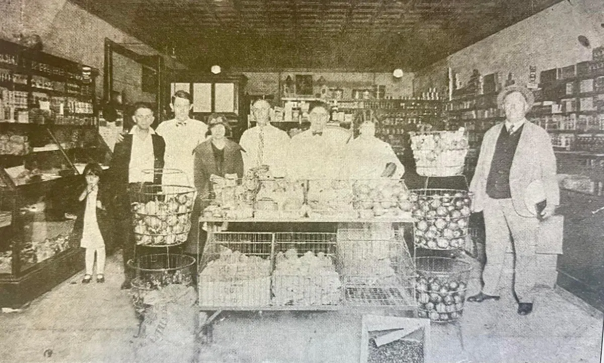 a vintage photo of a group of people standing in front of a building